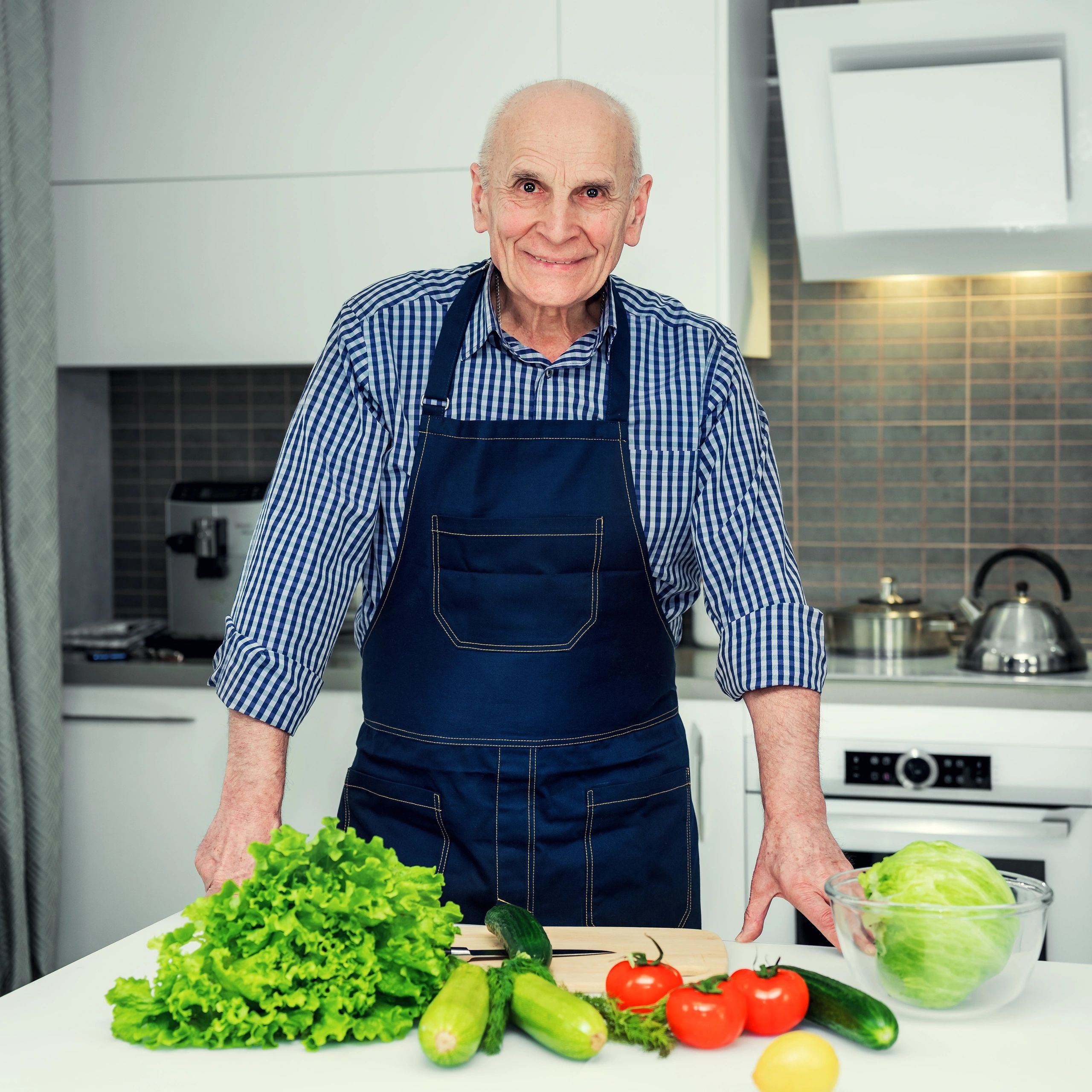 Professional chef standing in a kitchen beside fresh ingredients